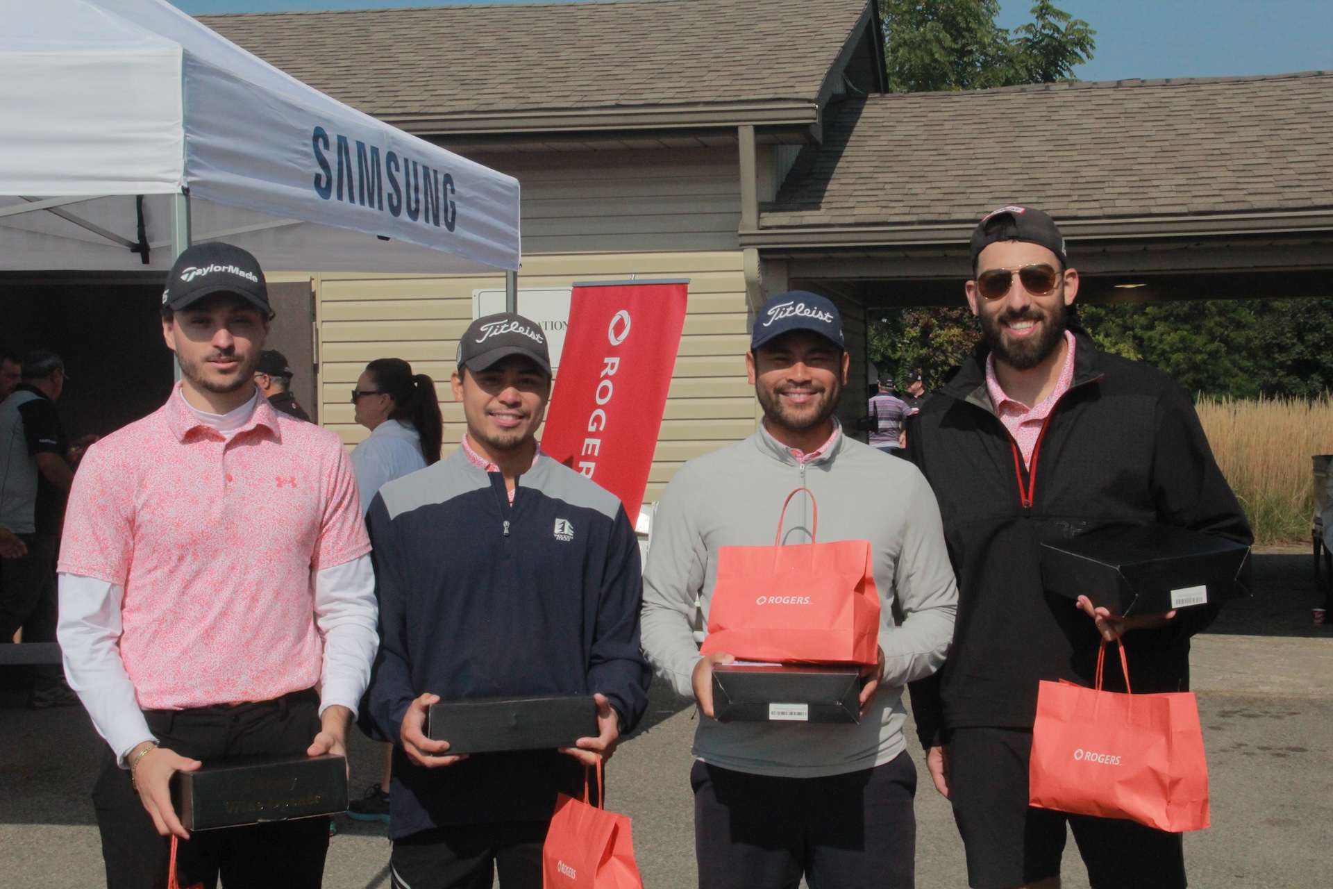 WCP team members holding prize boxes and Rogers gift bags at the annual golf tournament